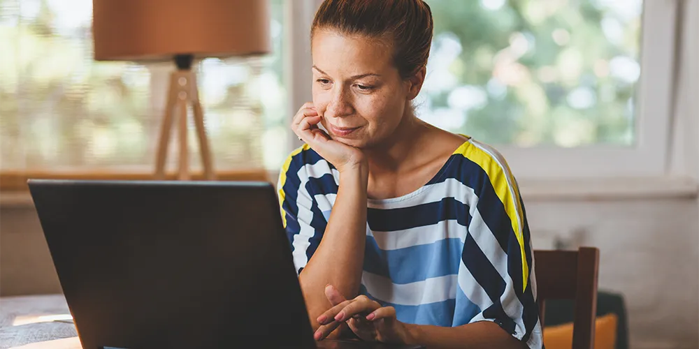 Eine Frau überprüft am Laptop ihr Vermögensdepot im Zweikontenmodell.